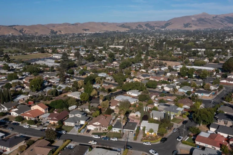 Aerial photo of a residential neighborhood in Fremont, California, showing single-family homes, trees, and surrounding hills in the distance.