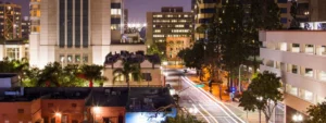 Downtown Santa Rosa at night with city lights, tall buildings, and light trails along Broadway Street.