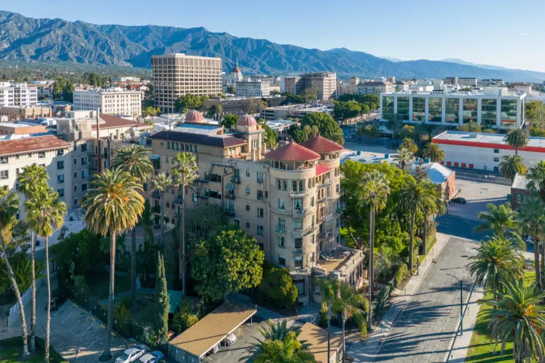 Downtown Pasadena with historic architecture, palm trees, and mountain backdrop.