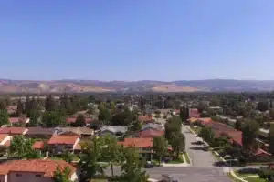 Aerial view of Simi Valley, California showing residential neighborhoods, rolling hills, and surrounding mountains under clear blue skies.