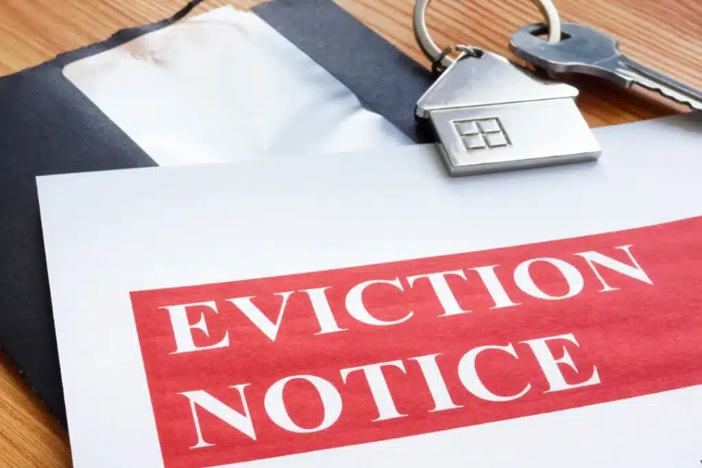 Eviction notice with house-shaped keychain and keys on a desk symbolizing tenant legal rights during eviction in California.