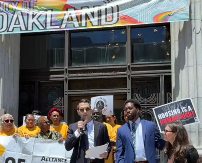 Rahman A. Popal speaking at an Oakland City Hall rally supporting tenants' rights and demanding accountability for housing code violations and unsafe living conditions.