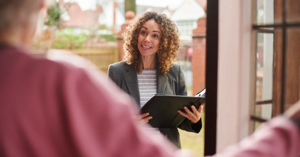 A woman discusses property options with a real estate agent in a professional setting.