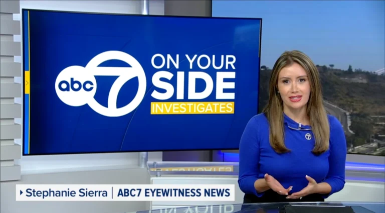 A news anchor holds a television screen displaying the phrase "On Your Side," conveying a message of support and information.