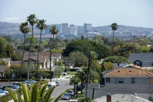 A panoramic view of a bustling city skyline with tall buildings and a clear blue sky.